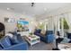 Bright living room features comfortable blue couches, a ceiling fan, and natural light from the outdoor balcony at 211 81St St # B, Holmes Beach, FL 34217