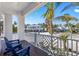 Relaxing front porch with blue chairs and a view of palm trees and a charming neighborhood at 211 81St St # B, Holmes Beach, FL 34217