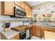 Modern kitchen features stainless steel microwave, granite counters, wooden cabinets, and decorative backsplash at 3007 Goodwater St, Sarasota, FL 34231