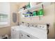 Bright laundry room equipped with a washer, dryer, shelving, and ample storage space at 3007 Goodwater St, Sarasota, FL 34231