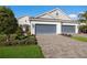 Charming home exterior with a paved driveway, lush landscaping, and a two-car garage at 3024 Sky Blue Cv, Bradenton, FL 34211