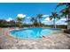 Beautiful community pool with surrounding palm trees, lounge chairs, and paved pool deck at 3024 Sky Blue Cv, Bradenton, FL 34211