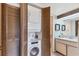 Bright bathroom featuring a washer and dryer and a vanity with framed mirrors above at 3073 Willow Grn # 36, Sarasota, FL 34235