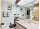 Bright bathroom featuring a large mirror and a shower with a tropical-themed curtain at 3073 Willow Grn # 36, Sarasota, FL 34235