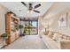 Bright living room features a plush sofa, a large window, and a bookcase with decorative items at 3073 Willow Grn # 36, Sarasota, FL 34235