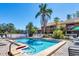 Community pool with lounge chairs surrounded by well-maintained landscaping and mature palm trees at 3073 Willow Grn # 36, Sarasota, FL 34235