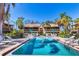 Resort-style pool with lounge chairs, green umbrellas, and condo views on a bright, sunny day with clear blue skies at 3073 Willow Grn # 36, Sarasota, FL 34235