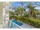 Balcony view of the sparkling pool and hot tub, surrounded by tropical landscaping and mature trees at 3319 S Osprey Ave, Sarasota, FL 34239