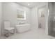 Modern bathroom featuring a soaking tub, a glass-enclosed shower, and white marble tile at 3319 S Osprey Ave, Sarasota, FL 34239