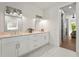 Bright bathroom with double sinks, white cabinets, modern fixtures, and a view of the bedroom at 3319 S Osprey Ave, Sarasota, FL 34239