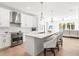 Bright, all-white kitchen with stainless steel appliances, island with bar seating, and hardwood flooring at 3319 S Osprey Ave, Sarasota, FL 34239