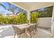 Inviting outdoor dining area on a covered patio, featuring a stylish table and chairs with lush landscaping views at 3319 S Osprey Ave, Sarasota, FL 34239