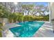 Sparkling pool amidst lush landscaping, offers a serene retreat with blue waters and sunlit tranquility at 3319 S Osprey Ave, Sarasota, FL 34239