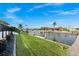 Beautiful waterfront backyard with lush lawn leading to a private boat dock on a sunny day at 360 Capri Isles Ct, Punta Gorda, FL 33950