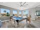 Game room featuring a pool table, ceiling fan, and windows that offer beautiful water views with modern decor at 360 Capri Isles Ct, Punta Gorda, FL 33950