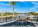 Hot tub overlooking a waterfront with boats, lush palm trees, and clear blue skies perfect for outdoor relaxation at 360 Capri Isles Ct, Punta Gorda, FL 33950