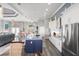 Modern kitchen with stainless steel appliances, large island, modern chairs, and views into the living room at 360 Capri Isles Ct, Punta Gorda, FL 33950