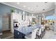 Spacious kitchen featuring white cabinetry, a large granite island with seating, and modern appliances with an open view at 360 Capri Isles Ct, Punta Gorda, FL 33950