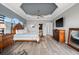 Elegant main bedroom featuring a tray ceiling, hardwood floors, and a seating area with modern decor and an ensuite at 360 Capri Isles Ct, Punta Gorda, FL 33950