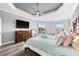 Bright and airy main bedroom with a large dresser, tray ceiling, and waterfront views, creating a relaxing atmosphere at 360 Capri Isles Ct, Punta Gorda, FL 33950