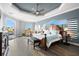 Large main bedroom featuring a tray ceiling, hardwood floors, a seating area, and waterfront views with modern decor at 360 Capri Isles Ct, Punta Gorda, FL 33950