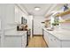 Well-lit kitchen with white cabinetry, quartz countertops, floating shelves, and stainless appliances at 3608 Spainwood Dr, Sarasota, FL 34232