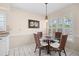 Cozy dining area with a round glass table and four rattan chairs near a window with shutters at 4527 La Jolla Dr, Bradenton, FL 34210