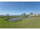 Scenic view of a pond with fountain, palm trees and condo exterior at 4734 Independence Dr # 4734, Bradenton, FL 34210