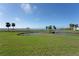 Expansive green lawn with pond, fountain, palm trees, and water views at 4734 Independence Dr # 4734, Bradenton, FL 34210