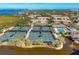 Aerial view of a complex featuring tennis courts, a swimming pool, and well-maintained condo buildings near the water at 4920 Kestral Park Cir # 11, Sarasota, FL 34231
