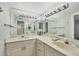 Bathroom with double sinks, white cabinets, and large mirror with Hollywood lights at 4920 Kestral Park Cir # 11, Sarasota, FL 34231