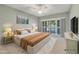 Staged bedroom with a large bed, nightstands, and a sliding door that lets in plenty of light at 4920 Kestral Park Cir # 11, Sarasota, FL 34231