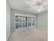 Bedroom with neutral carpet, ceiling fan, and sliding door access to the outdoors at 4920 Kestral Park Cir # 11, Sarasota, FL 34231