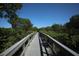 Long wooded boardwalk surrounded by green lush mangrove trees and blue skies overhead at 4920 Kestral Park Cir # 11, Sarasota, FL 34231