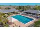 Aerial view of the community pool, surrounded by lounge chairs and lush landscaping at 4920 Kestral Park Cir # 11, Sarasota, FL 34231