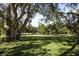 Scenic view of lush green property featuring mature trees and a gravel walking path at 4920 Kestral Park Cir # 11, Sarasota, FL 34231