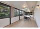Enclosed patio with neutral tile flooring, dining set, and lots of windows bringing the outdoors in at 4920 Kestral Park Cir # 11, Sarasota, FL 34231