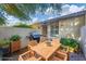 Cozy brick patio featuring a wooden dining table set, grill, and lush greenery, perfect for outdoor entertaining at 4920 Kestral Park Cir # 11, Sarasota, FL 34231