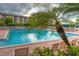 Community pool surrounded by lush landscaping and lounge seating at 4920 Kestral Park Cir # 11, Sarasota, FL 34231