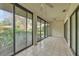 Bright and sunny sun room featuring tile floor and large sliding glass windows overlooking backyard at 4920 Kestral Park Cir # 11, Sarasota, FL 34231