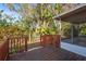 Wood deck with railing and a glimpse of a screened-in porch offers a serene outdoor retreat at 4999 Linwood St, Sarasota, FL 34232