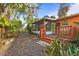 Backyard with a wood deck, screened in patio, lush landscaping and a stone pathway at 4999 Linwood St, Sarasota, FL 34232