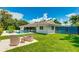 Relaxing backyard area with comfortable seating overlooking the pool and lush green lawn at 526 Bird Key Dr, Sarasota, FL 34236