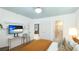 Light filled bedroom showcasing a ceiling painted blue, wood floors, TV and ensuite bathroom at 526 Bird Key Dr, Sarasota, FL 34236