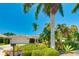 Inviting single-story home featuring a manicured lawn, lush tropical landscaping, and a clean, bright exterior at 526 Bird Key Dr, Sarasota, FL 34236