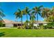 Beautiful home featuring lush tropical landscaping, well-manicured lawn, and a bright exterior with an attached two-car garage at 526 Bird Key Dr, Sarasota, FL 34236