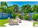 Inviting patio area with comfortable seating amidst vibrant tropical plants and a manicured lawn at 526 Bird Key Dr, Sarasota, FL 34236