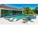 Stunning backyard showcasing a sparkling pool, a spa, stylish lounge chairs, and sleek, modern architecture at 526 Bird Key Dr, Sarasota, FL 34236