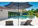 Beautiful backyard with a refreshing pool, spa, ample seating, and a lush tropical landscape for ultimate relaxation at 526 Bird Key Dr, Sarasota, FL 34236