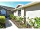 A close up shot of the exterior of a property highlighting the walkway, siding and surrounding landscaping at 5283 Chase Oaks Dr, Sarasota, FL 34241